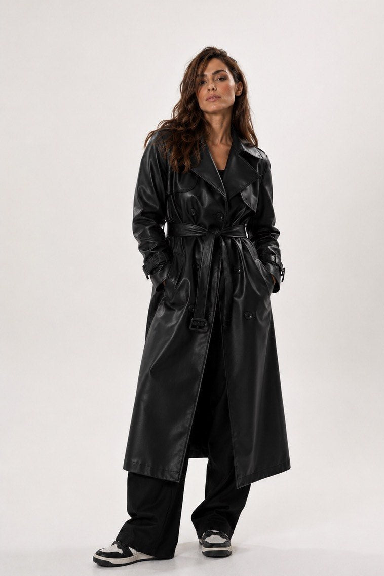 Person wearing a black leather trench coat on a white background